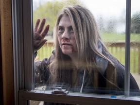 Jennifer Baldwin channels her inner zombie as she looks through the window into the survivors base during Zombie Survival Camp near Orillia, Ont., on May 14, 2017. The Telus World of Science in Edmonton is hosting an adults-only zombie apocalypse survival challenge on Saturday, June 3, 2017.