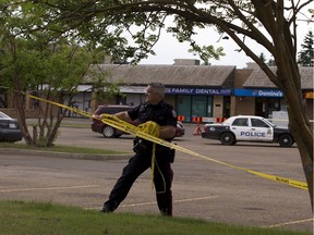 Police take down tape at the scene of a suspicious death at a strip mall located at Hermitage Road an 40th Street on Thursday June 1, 2017, in Edmonton.