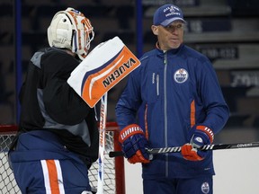 Oilers goalie Ben Scrivens (left) speaks with assistant coach Kelly Buchberger during practice at Rexall Place in Edmonton on Feb. 24, 2014.