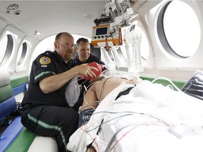 Paramedic clinical educator Chris Bassil, left, and flight paramedic Michel Lacasse run a drill inside Canada's first mobile flight simulator for air ambulance training during an unveiling at the STARS Edmonton base at Edmonton International Airport on Thursday, June 1, 2017.