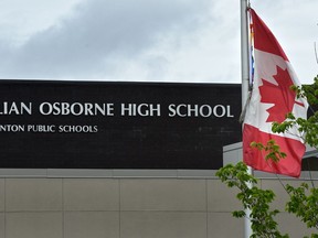 A piece of the torn Pride flag is still visible next to the Canada flag outside Lillian Osborne High School in Edmonton on Saturday, June 11, 2017.