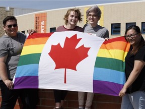 (Left to right) Jennifer Jones, Kennedy Harper, Christina Crowell and Amanda Paulino, members of the Blessed Oscar Romero High School's Rainbow Ravens gay-straight alliance, pose for a photo with a Pride flag in Edmonton on Wednesday, June 7, 2017.