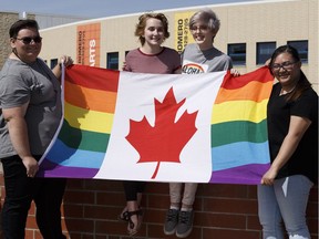 (Left to right) Jennifer Jones, Kennedy Harper, Christina Crowell and Amanda Paulino, members of the Blessed Oscar Romero High School's Rainbow Ravens gay straight alliance, pose for a photo with a Pride flag in Edmonton on Wednesday, June 7, 2017. The principal of their school apologized after staff members made students take down Pride Week flags.