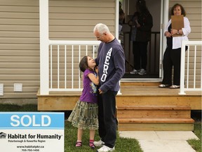 A family gets the keys to their new Habitat for Humanity home, one part of the spectrum of affordable or non-market housing possible.