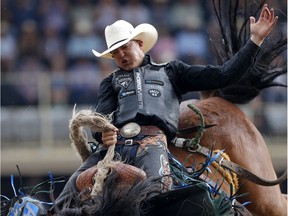 Zeke Thurston of Big Valley, Alberta rides Get Smart to win saddle bronc championship at the Calgary Stampede on Sunday July 16, 2017.