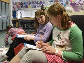 Swanavon School students Keira Latham, left, and Emily Short discuss Alberta's geography during social studies class on April 24, 2017 in Grande Prairie, Alta. The Alberta government is rewriting the social studies curriculum.