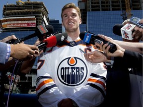 Edmonton Oilers star Connor McDavid speaks to reporters nearconstruction at downtown Edmonton's Ice District after signing an eight-year, $100-million contract extension with the team on July 5, 2017.