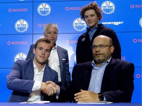 Edmonton Oilers star Connor McDavid shakes hands with general manager Peter Chiarelli while Oilers Entertainment Group vice-chairman Bob Nicholson, back left, and Harrison Katz, son of Oilers owner Darryl Katz, look on during a media conference July 5, 2017, at Rogers Place, where McDavid signed an eight-year contract extension with the NHL club worth $12.5-million a year.