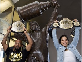 UFC flyweight champion Demetrious Johnson and women's bantamweight champion Amanda Nunes pose for a photo beside the Wayne Gretzky statue outside Rogers Place during a media availability, in Edmonton Wednesday July 26, 2017.