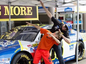 Johnathan Strecheniuk, 10, teaches NASCAR driver Alex Tagliani how to dab at a Lowe's store, 9603 165 Ave., in Edmonton on Friday, July 28, 2017.