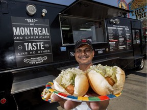 Abhijeet Chougule displays a couple of Montreal Steamies at the Montreal Hotdogs food truck at K-Days, in Edmonton Saturday July 29, 2017.