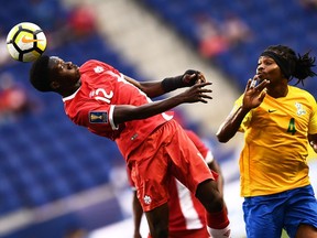 Canada midfielder Alphonso Davies, left, and French Guiana's forward Rhudy Evens vie for the ball during their 2017 Concacaf Gold Cup Group A match at the Red Bull Arena in Harrison, New Jersey, on July 7, 2017.