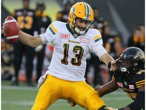 Edmonton Eskimos quarterback Mike Reilly (13) fends off Hamilton Tiger-Cats defensive back Terrence Frederick (25) during first half CFL football action in Hamilton, Ont. on Thursday, July 20, 2017.