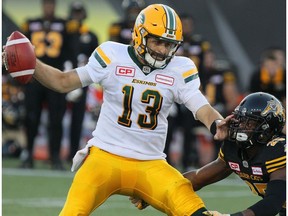 Edmonton Eskimos quarterback Mike Reilly (13) fends off Hamilton Tiger-Cats defensive back Terrence Frederick (25) during first half CFL football action in Hamilton, Ont. on Thursday, July 20, 2017.
