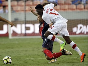 Costa Rica's David Ramirez, back, hits the ground after being tackled by Canada's Alphonso Davies, front, in the second half of a CONCACAF Gold Cup soccer match in Houston on July 11, 2017.