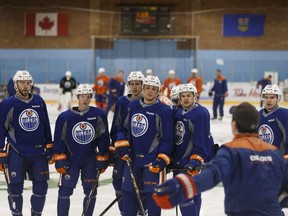 Edmonton Oilers assistant coach Jay Woodcroft, right, speaks with team prospects during development camp at Jasper Arena on July 5, 2017.