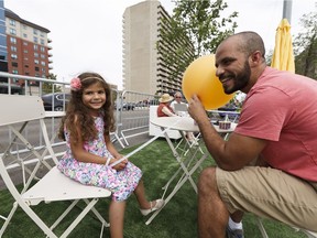 Mohamed Omar and his daughter Laila, 4, check out seating placed in Jasper Avenue during the Experience Jasper Avenue event in Edmonton on Saturday, July 15, 2017.