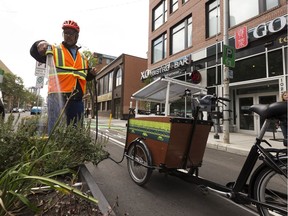 Peter Mueller, a park operations co-ordinator with the City of Edmonton, demonstrates how one of two solar-powered watering tricycles is used, during a news conference on 103 Street in downtown Edmonton on Friday, July 21, 2017.