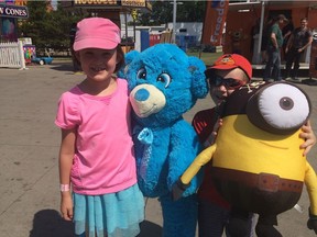 Sophie Carder, 7, and her younger brother, Liam Carder, 4, pose with their winnings from games on the K-Days midway.