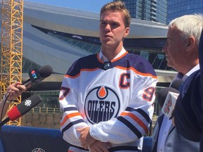 Connor McDavid wears the new white Edmonton Oilers jersey designed by Adidas outside Rogers Place following a media conference announcing he had signed an eight-year contract extension with the NHL team.