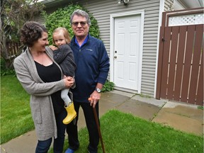 Kim Ziola (right), an architect with multiple sclerosis, would like to build a wheelchair-acccessible garage suite for himself and his wife on his daughter's lot in King Edward Park. He'll need a wheelchair eventually. His daughter, Tai Ziola (left) is shown holding granddaughter Ada, 3, on Tuesday, July 11, 2017.