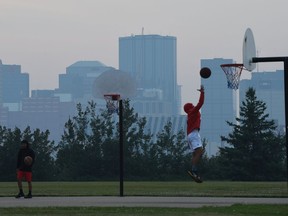 Smoke from the B.C. wildfires blanketed Edmonton Sunday as boys play basketball in Forest Heights Park on July 16, 2017.