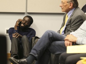 Desmond Cole talks on a cellphone at the Toronto Police Services Board meeting along with members of Black Lives Matter at the on Thursday June 15, 2017. Cole will speak in Edmonton on the controversial practice of police carding this weekend.