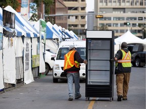 Crews push a cooler down 99 Street as they work to set up for the Taste of Edmonton, Tuesday, July 18, 2017.