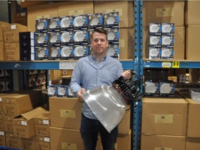 Adventure Warehouse and Ultimate Lights manager Cory Tretiak holds a 150-watt LED high bay light with prismatic reflector in Airdrie.