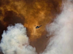 A helicopter battles a wildfire in Fort McMurray on May 4, 2016. The fire, which smouldered underground for months, is finally completely extinguished.