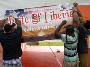 Reuben Tucker, Gizzie Arku and Edmond Wilson work to set up the Liberian pavilion in preparation for this weekend's Heritage Festival at Hawrelak Park.
