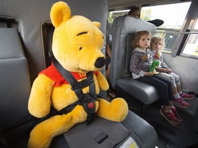 Sisters Haidyn Kurek, 5, and Harper Kurek, 3, sit in a school bus with Winnie the Pooh during the 12th annual First Riders event at Northlands, in Edmonton on Thursday, Aug. 31, 2017. The First Riders program helps students become familiar and comfortable with the bus-riding experience before the first day of school.