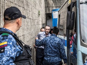 Canadian miner Norbert Reinhart is led from a hearing at a Colombian court to a prison bus in June 2015. The Canadian diamond driller, who made headlines as a captive of the FARC in the late 1990s, is in prison in Medellín after being accused of arranging the murder of a business partner —charges he and his daughter Molly vehemently deny.