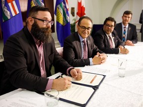 (From left) Alberta Municipal Affairs Minister Shaye Anderson, Alberta Finance Minister Joe Ceci, Calgary Mayor Naheed Nenshi and Edmonton Mayor Don Iveson sign a new charter as the provincial government reveals details of new city charters for Edmonton and Calgary at the Alberta Legislature Building in Edmonton on Thursday, Aug. 10, 2017.