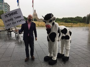 Progress Alberta executive director Duncan Kinney with Becky the Cow outside the Federal Building in Edmonton on Aug. 1, 2017