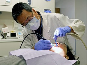 Dr. Ivan Chin performs dental work on a patient at the Boyle McCauley Health Centre in Edmonton on Thursday, Aug. 17, 2017, when the Alberta Dental Association and College released a new dental fee guide for Alberta. Currently, Alberta dental fees are higher than the other provinces in Canada.
