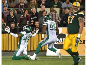 Saskatchewan Roughriders Kacy Rodgers II (45) celebrates touchdown with Antonio Longino (95) after his interception against the Edmonton Eskimos during CFL action at Commonwealth Stadium in Edmonton, August 25, 2017.