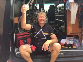 Malcolm Stinson, 57, holds up a glass of champagne in celebration after completing his 30th half-ironman race on Sunday, July 30, 2017 at Hawrelak Park in Edmonton.