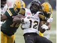 Hamilton Tiger-Cats' C.J. Gable (32) is tackled by Edmonton Eskimos Christophe Mulumba-Tshimanga (10) and D'Anthony Batiste (64) during first half CFL action in Edmonton, Alta., on Friday August 4, 2017.
