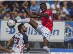 Tomi Ameobi of FC Edmonton, right, goes high to receive a pass  despite Marco Franco of the Indy Eleven at Clarke Stadium kicking off the fall NASL season in Edmonton on July 29, 2017.