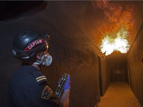 Assistant chief training officer Mike Prangley uses a remote control to simulate a rollover scenario in a hallway, when super heated gases collect in a confined space and ignite, at Edmonton Fire Rescue Services' Poundmaker training facility on Aug. 24, 2017.
