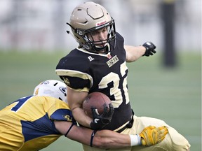 Edmonton Huskies' Jimmie Airey is tackled by Edmonton Wildcats' James Ens during their Prairie Football Conference junior football game at Clarke Stadium on Sept. 17, 2016.