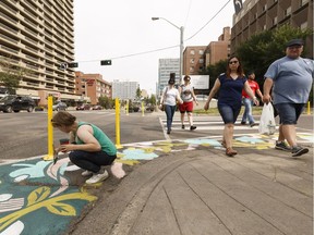Artist Jill Stanton paints in Jasper Avenue as pedestrians walk by during the Experience Jasper Avenue event in Edmonton on Saturday, July 15, 2017.