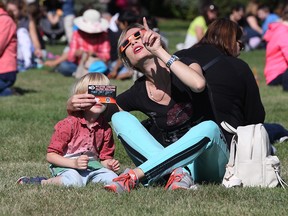 Yulia Shevtsov and her son Steven Shevtsov, 3, watch the partial eclipse of the sun during a viewing party outside Telus World of Science, Monday Aug. 21, 2017.