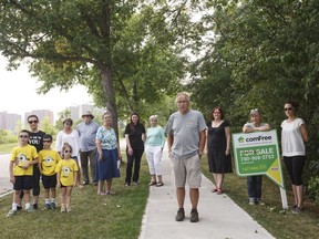 Bill McGowan, centre,  stands with neighbours in front of a home that used to belong to former mayor Joe Clarke in Edmonton August 13, 2017.