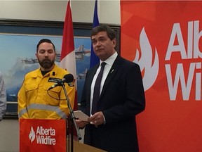 Agriculture and Forestry Minister Oneil Carlier, right, announces a ban on off-highway vehicle use in public forests in southern Alberta on Tuesday, Aug. 1, 2017.