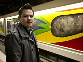 Aaron Paquette poses with the murals he painted at the Grandin LRT station in Edmonton, Alta., on Friday, March 21, 2014. The new murals were the outcome of two years of dialogue among the city's aboriginal and Francophone communities.