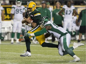 Edmonton Eskimos quarterback Mike Reilly is tackled by the Saskatchewan Roughriders defensive lineman Ese Mrabure during CFL action at Commonwealth Stadium in Edmonton on Aug. 26, 2016.