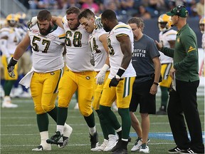 Edmonton Eskimos offensive lineman Jean-Simon Roy is helped off the field during CFL action against the Winnipeg Blue Bombers in Winnipeg on Thurs., Aug. 17, 2017.