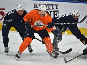 Edmonton Oilers' Ryan Stanton (20) beats Zack Kassian (44) and Jujhar Khaira (16) to the puck during the first day of training camp at Rogers Place in Edmonton, September 15, 2017.